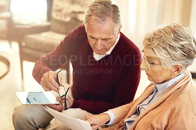 Buy stock photo Shot of an elderly couple working out a budget while sitting on the living room sofa