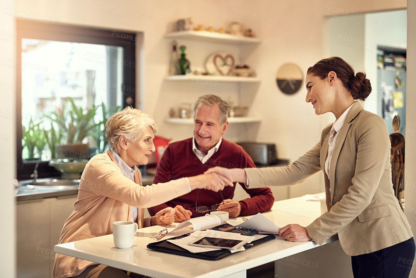 Buy stock photo Senior couple, accountant and handshake in finance, budget or agreement for consultation at home. Happy elderly man and woman shaking hands with consultant lawyer for financial planning or investment