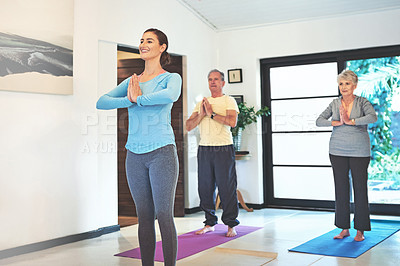 Buy stock photo Shot of a yoga instructor guiding a senior couple in a yoga class