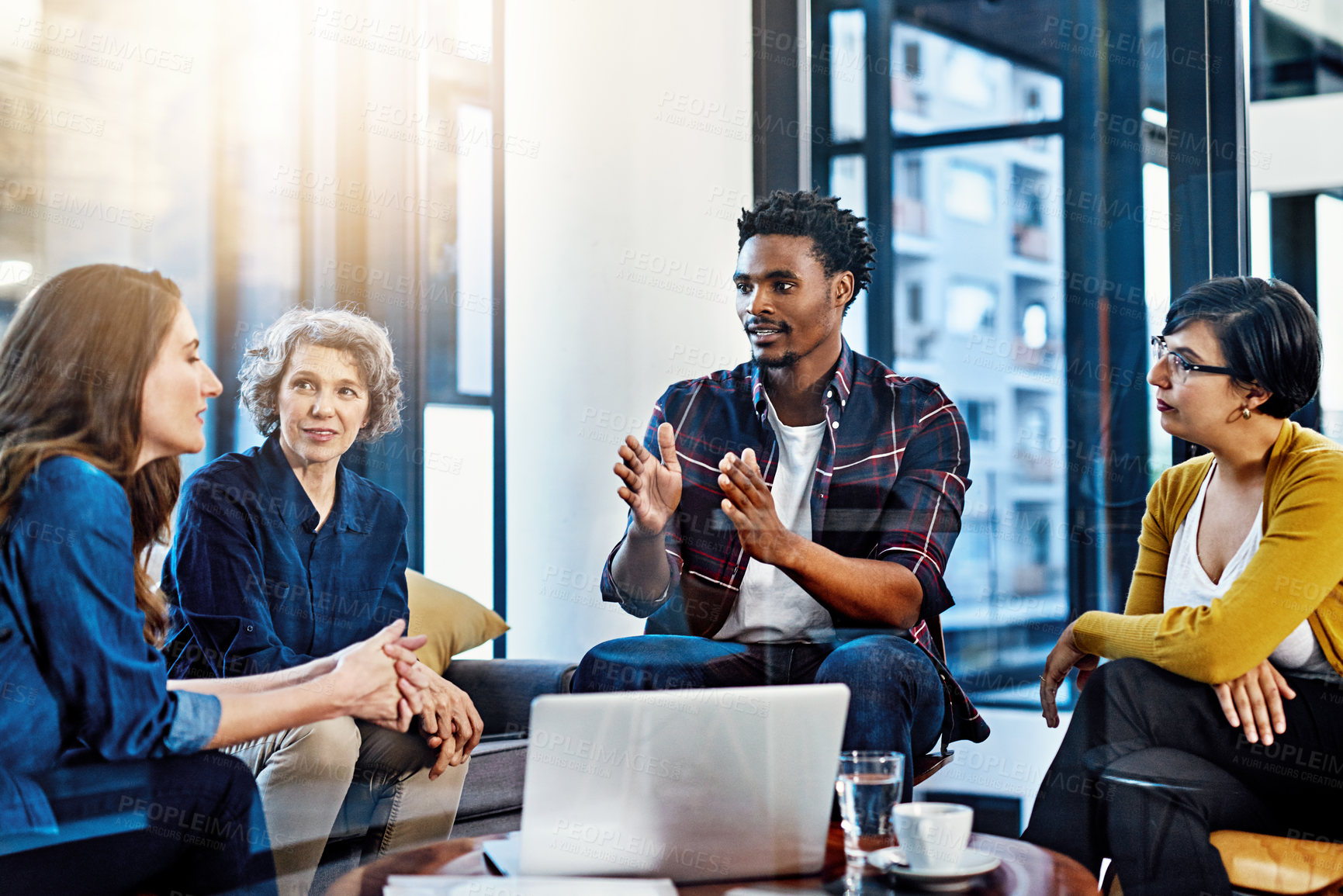 Buy stock photo Cropped shot of a group of colleagues having a meeting in a modern office