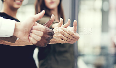 Buy stock photo Closeup shot of a group of businesspeople showing thumbs up together in an office