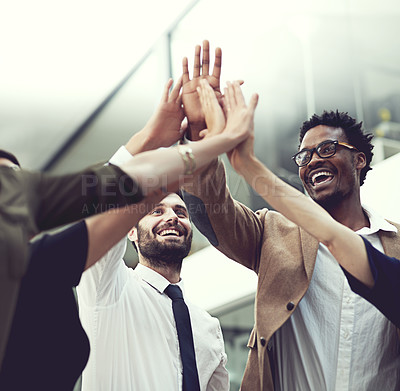 Buy stock photo Closeup shot of a group of businesspeople giving each other a high five in an office