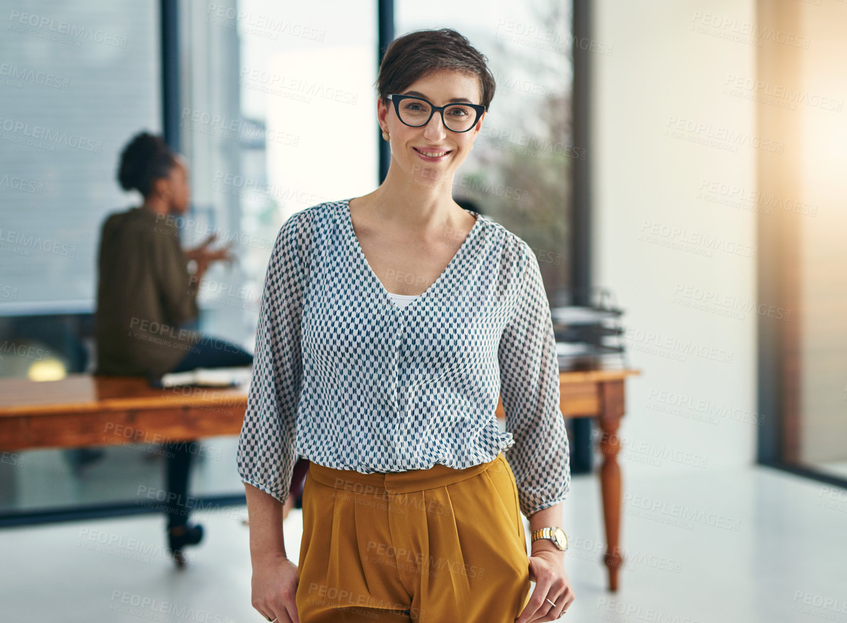 Buy stock photo Portrait of a young creative standing in an office with colleagues in the background