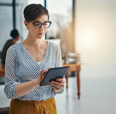 Buy stock photo Cropped shot of a young creative working on a digital tablet in an office