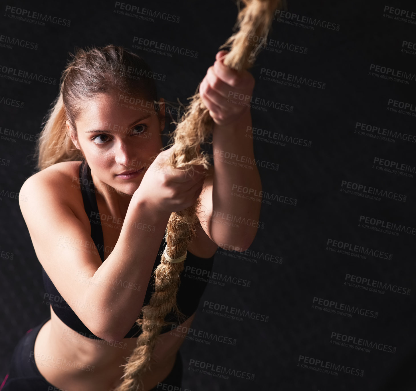 Buy stock photo Rope climbing, fitness and woman with top view in studio for power workout, strength or intense cardio on dark background. Above, athlete and person for performance, muscle endurance or training