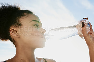 Buy stock photo Closeup shot of a sporty young woman drinking water after her workout