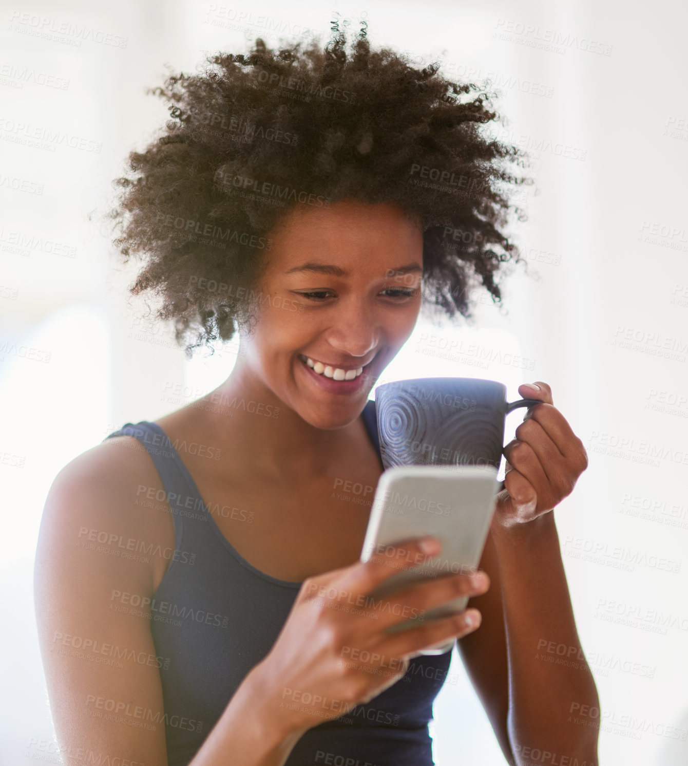 Buy stock photo Shot of an attractive young woman drinking coffee at home while reading a text message