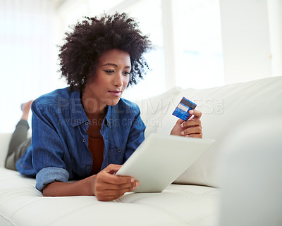 Buy stock photo Shot of an attractive young woman shopping online from the comfort of home