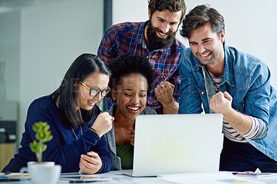 Buy stock photo Shot of a group of creative businesspeople cheering around a laptop in the office
