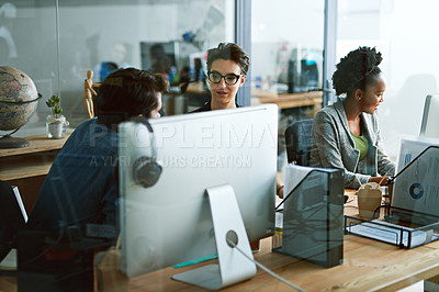 Buy stock photo Shot of two businesspeople talking in the office alongside a third colleague
