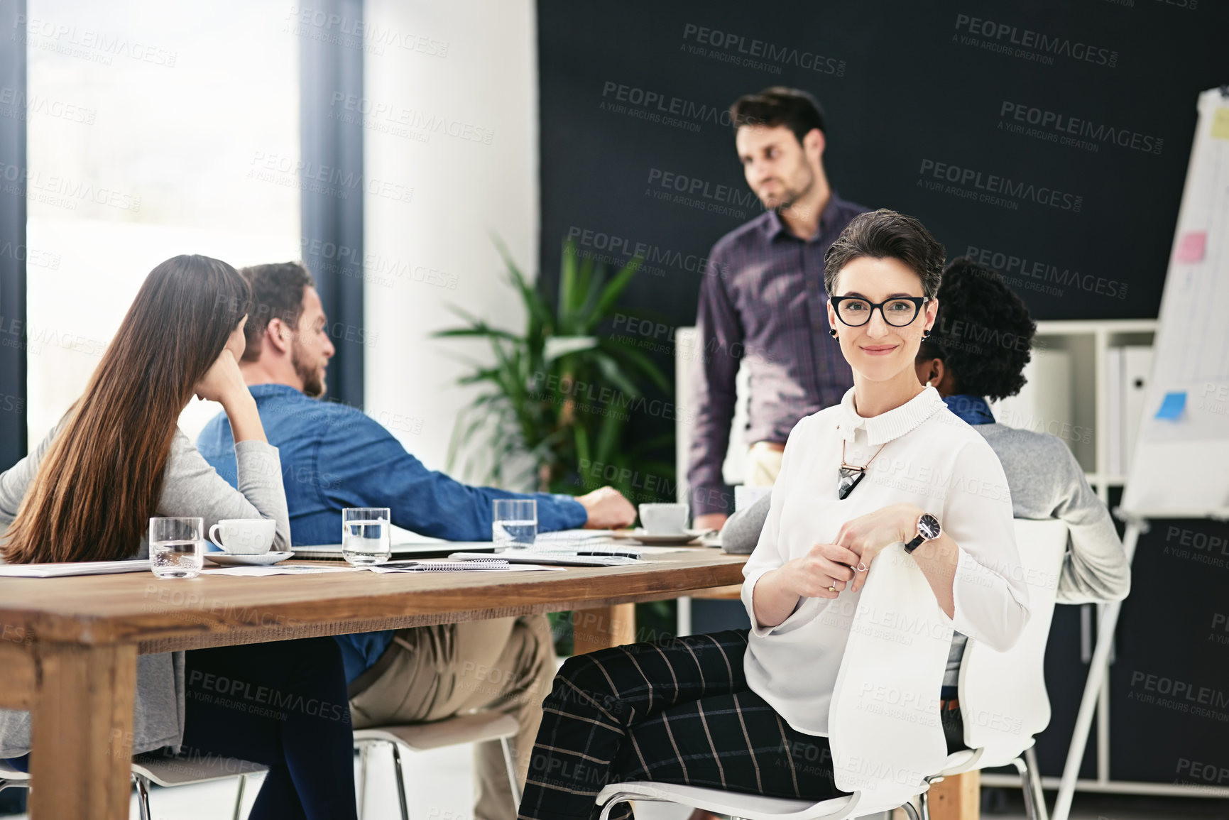 Buy stock photo Portrait, smile and business woman in office meeting for coworking, career and job in startup. Staff, glasses and happy professional entrepreneur with team, editor and creative manager in company