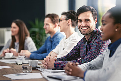 Buy stock photo Cropped portrait of a young businessman sitting in the boardroom during a meeting