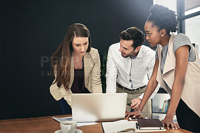 Buy stock photo Shot of a team of businesspeople using a laptop together at work