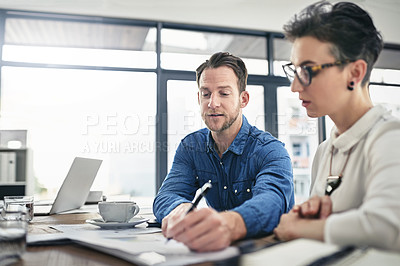 Buy stock photo Cropped shot of two young businesspeople talking during a meeting in the boardroom