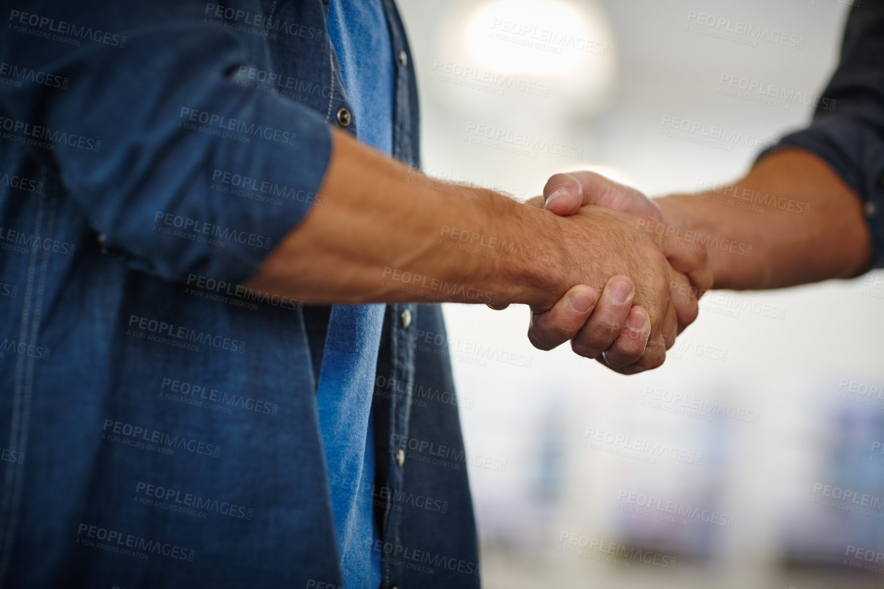 Buy stock photo Closeup shot of two businessmen shaking hands in an office