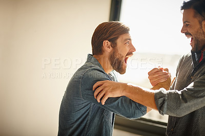 Buy stock photo Shot of two businessmen shaking hands together and shouting in celebration while standing in an office