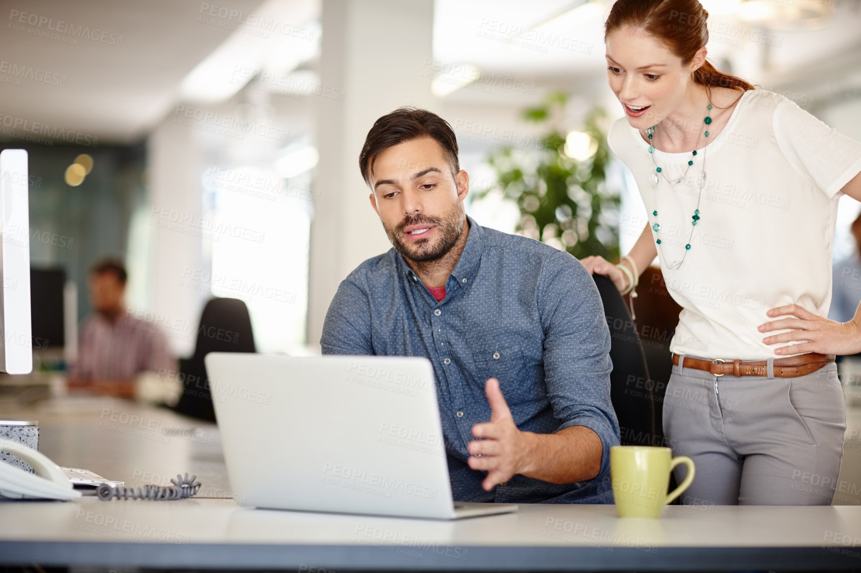 Buy stock photo Cropped shot of colleagues working together on a laptop in an office