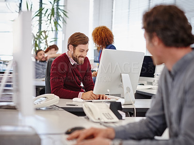 Buy stock photo Shot of business colleagues working on computers in their modern office