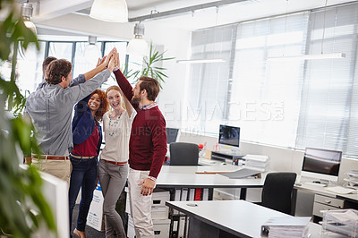 Buy stock photo Shot of a team of businesspeople giving each other a high five in the office
