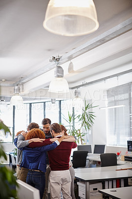 Buy stock photo Shot of a team of businesspeople forming a huddle in the middle of their office