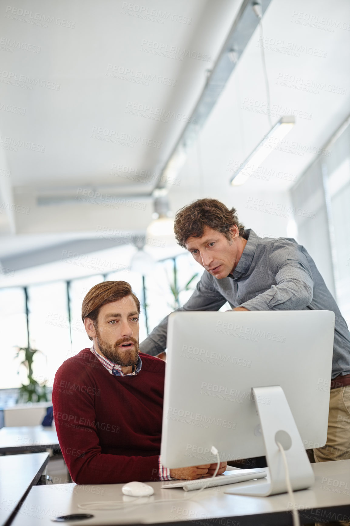 Buy stock photo Shot of a businessman and his colleague working together on a computer in the office