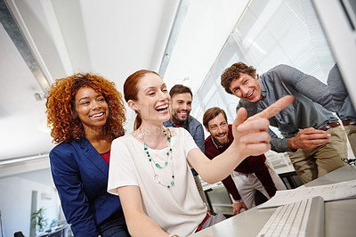 Buy stock photo Shot of a group of businesspeople looking at a computer together in the office