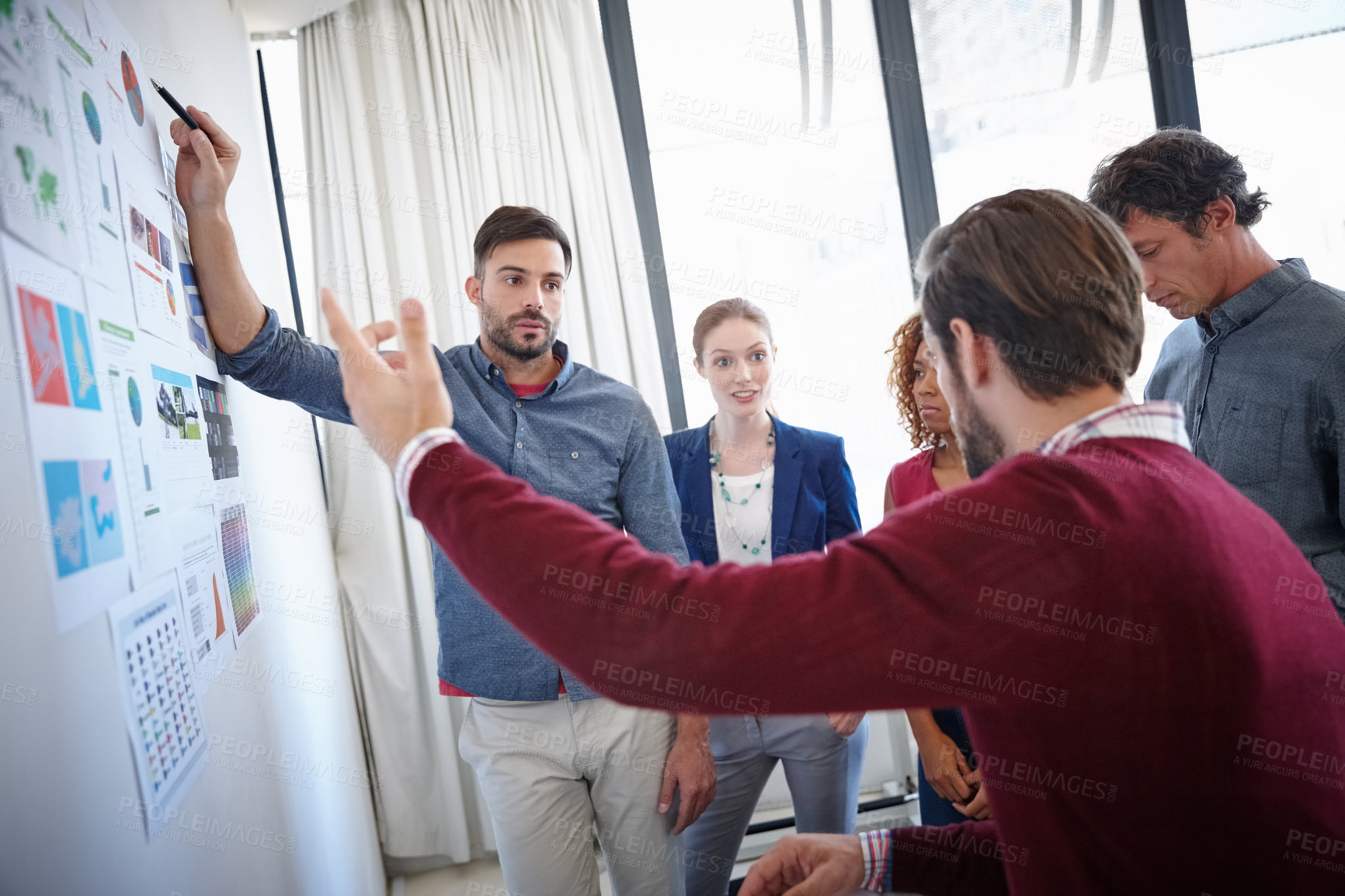 Buy stock photo Shot of a group of businesspeople listening to a colleague's presentation in the office