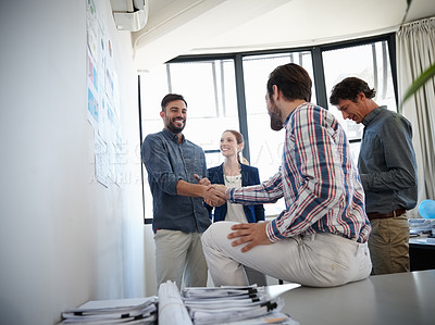 Buy stock photo Shot of colleagues shaking hands during a meeting at work