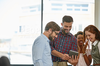 Buy stock photo Shot of a group of colleagues using a digital tablet together at work