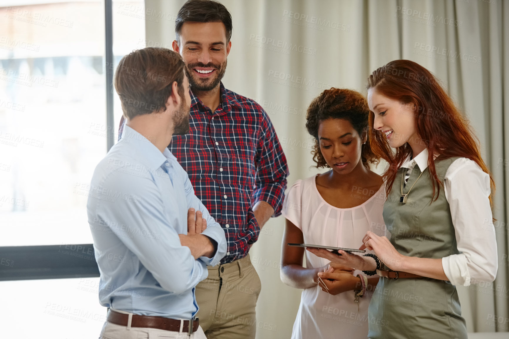 Buy stock photo Shot of a group of colleagues using a digital tablet together at work