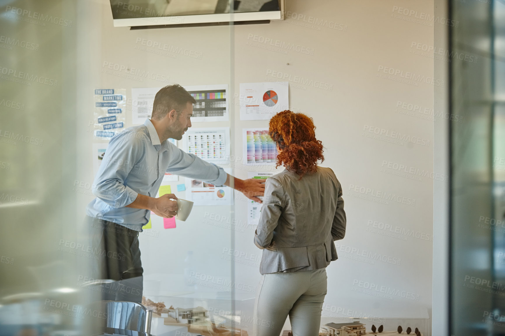 Buy stock photo Shot of two colleagues having a brainstorming session at work