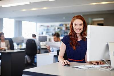 Buy stock photo Portrait of a happy businesswoman using a computer at her work desk