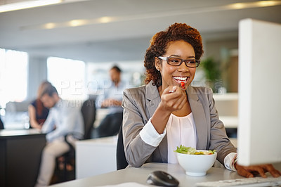 Buy stock photo Shot of a young businesswoman having a salad during her lunch break at her desk