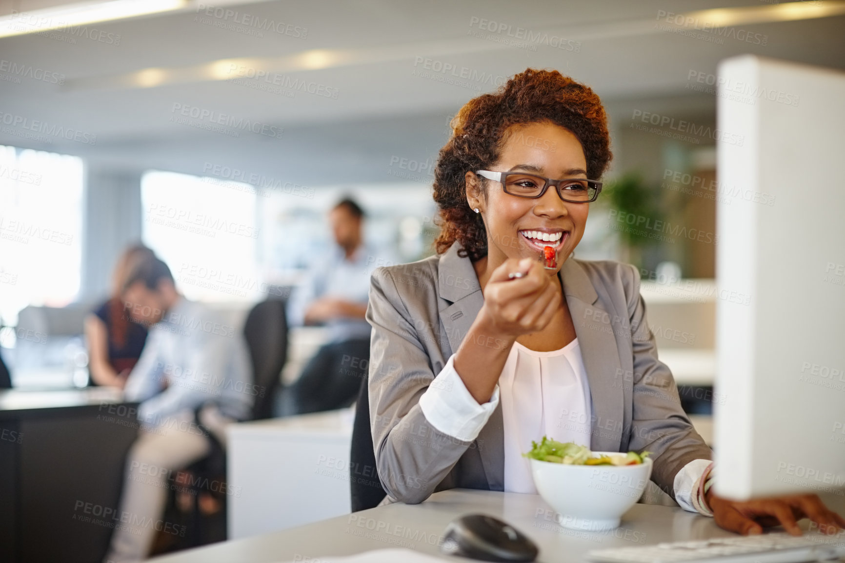 Buy stock photo Shot of a young businesswoman having a salad during her lunch break at her desk