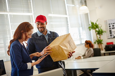 Buy stock photo Shot of a young woman receiving a package from a deliveryman at her office