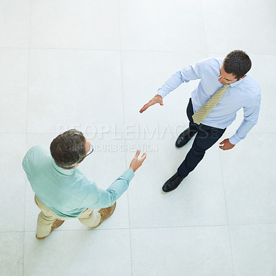 Buy stock photo High angle shot of two businessmen shaking hands in the office
