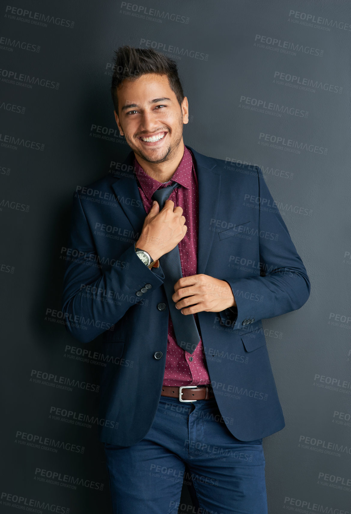 Buy stock photo Portrait of a handsome young businessman standing against a black background