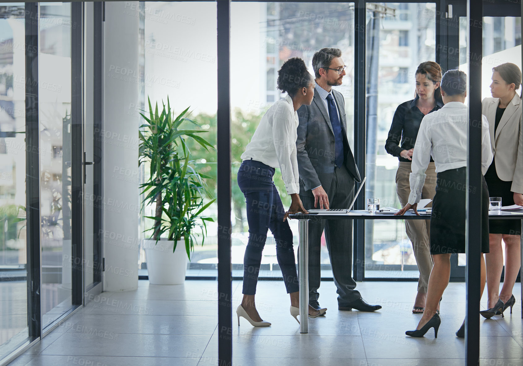 Buy stock photo Shot of a group of businesspeople having a serious discussion in the boardroom