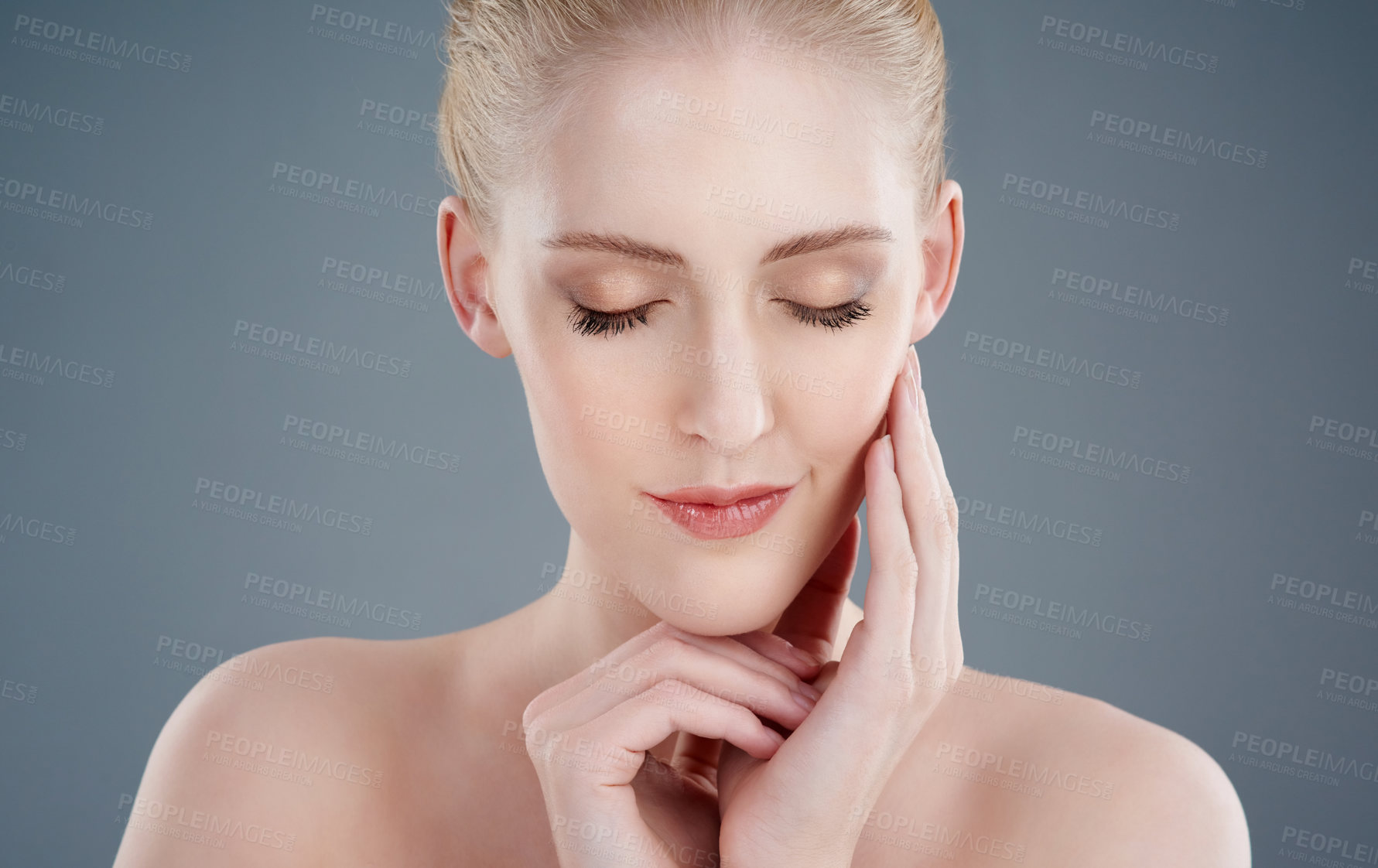 Buy stock photo Studio shot of a young woman with beautiful skin isolated on gray