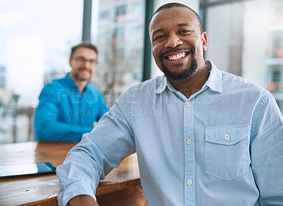 Buy stock photo Portrait of a businessman sitting in the office with a colleague in the background