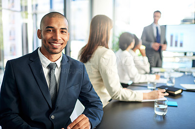 Buy stock photo Portrait of a young businessman sitting in a boardroom meeting with colleagues
