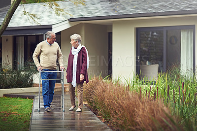 Buy stock photo Shot of a loving senior couple taking a walk outside