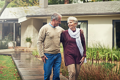 Buy stock photo Love, garden and senior couple walking by their house for wellness, fresh air and bonding. Happy, retirement and elderly man and woman on a path together in their garden at their modern home.