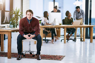 Buy stock photo Portrait of a confident businessman with his team working in the background
