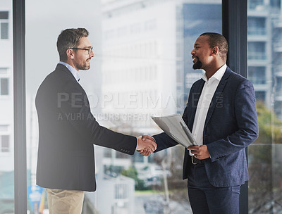 Buy stock photo Shot of two businessmen shaking hands at work