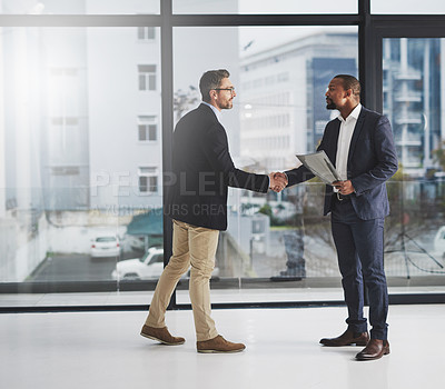 Buy stock photo Shot of two businessmen shaking hands at work