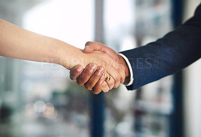 Buy stock photo Cropped shot of a businessman and businesswoman shaking hands at work