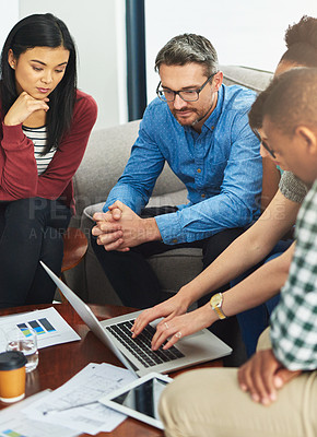 Buy stock photo Shot of a group of colleagues working together on a laptop