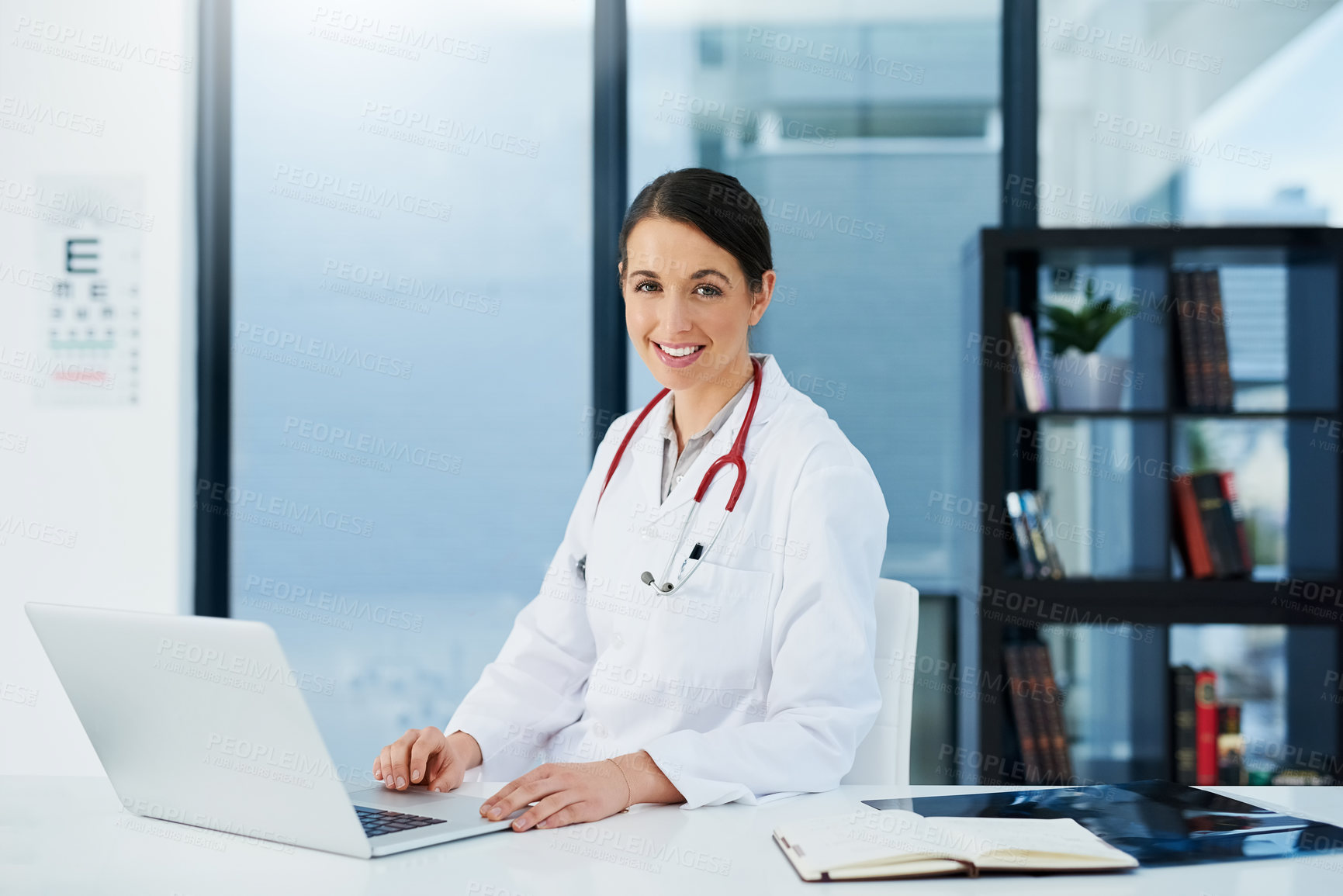 Buy stock photo Doctor, woman and portrait at desk with laptop, medical research and planning hospital schedule. Female person, smile and confident for healthcare, cardiologist and clinic website for expert medicare