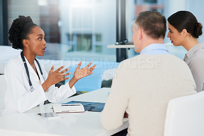 Buy stock photo Cropped shot of a female doctor talking to a married couple in her office